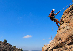 En kille klättrar på en vägg i bergen på Gran Canaria