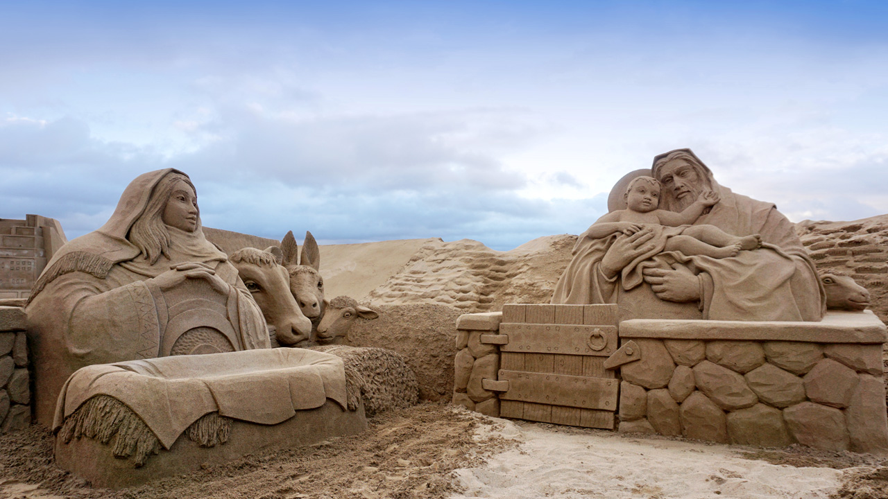 Sandskulpturen “julkrubban” på stranden Las Canteras