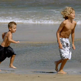 [] Dos niños corren por la orilla de Playa del Inglés
