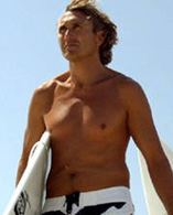 Un surfista cammina con la sua tavola sotto il braccio