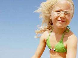 Criança a sorrir na playa de Maspalomas num dia de sol