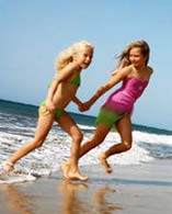 Bambine corrono sul bagnasciuga della spiaggia di Maspalomas