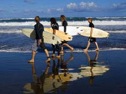 Vier Surfer mit ihren Boards am Strand von Las Canteras