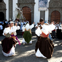 Gruppo di persone con i costumi tradizionali ballano durante le Feste del Pino