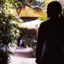 Una chica observa el interior de un patio canario en Vegueta