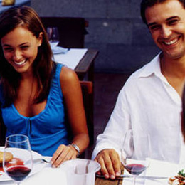 Una coppia sorridente con due bicchieri di vino