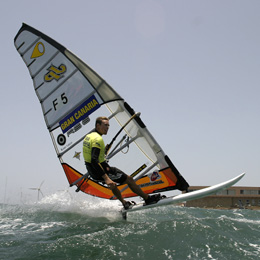 A windsurfer leaping over the waves