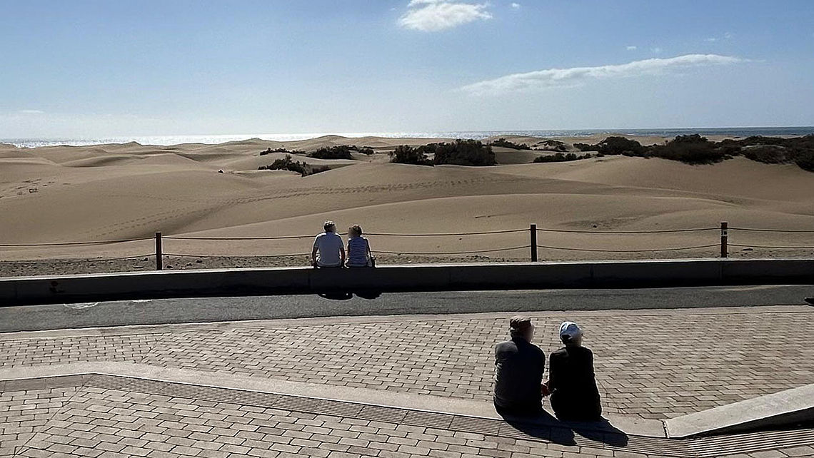 Varias personas disfrutan de las vistas de las Dunas de Maspalomas desde el mirador
