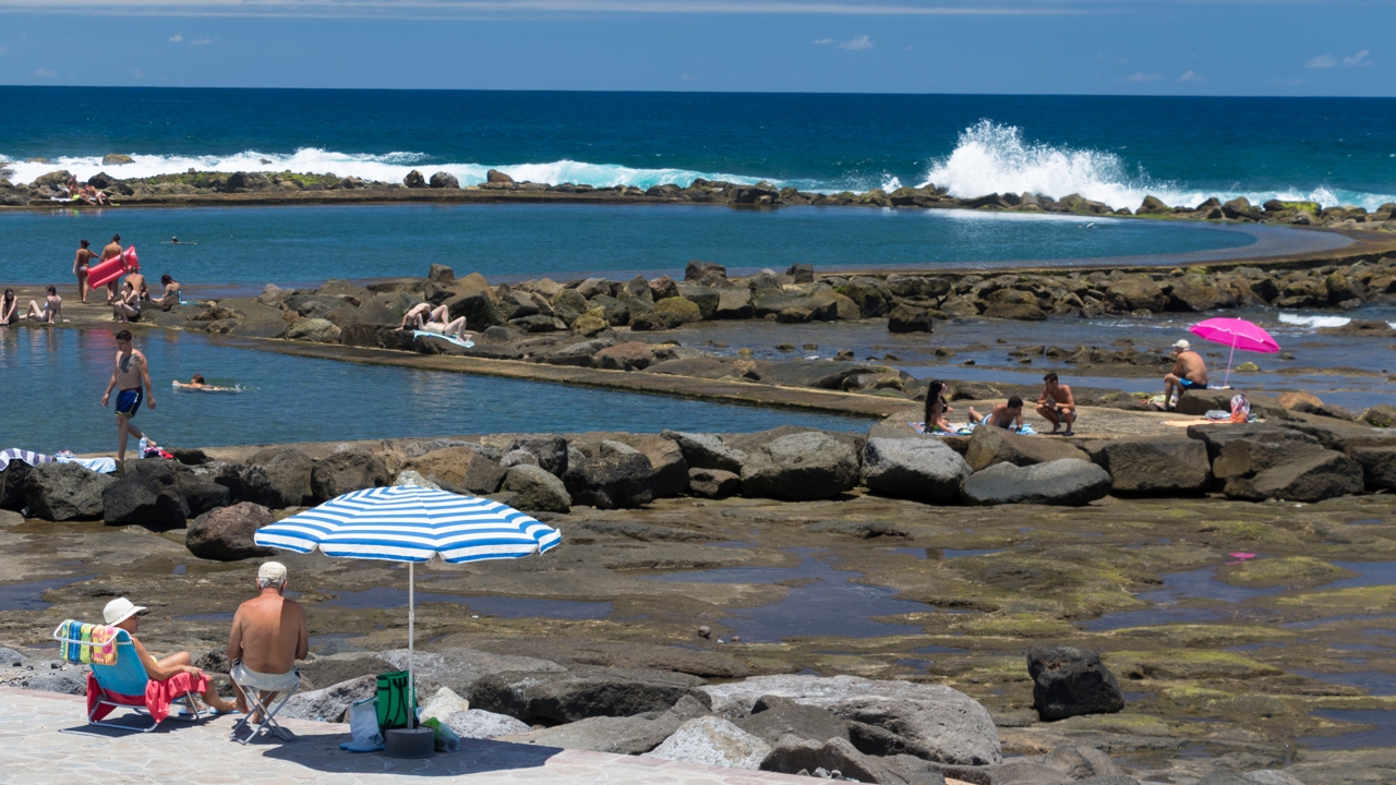 Varias personas disfrutan del día en las piscinas naturales Los Charcones, en Arucas