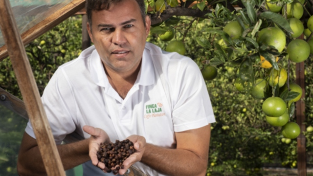 Victor mostrando granos de café