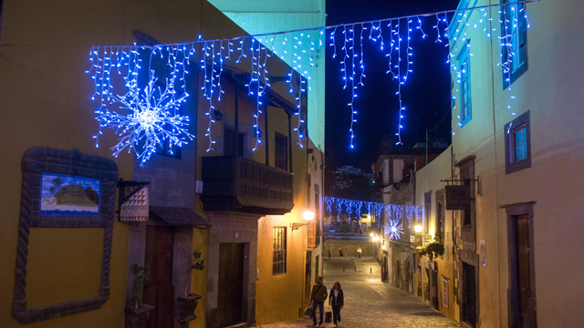 Una pareja pasea por una calle de Vegueta iluminada en Navidad