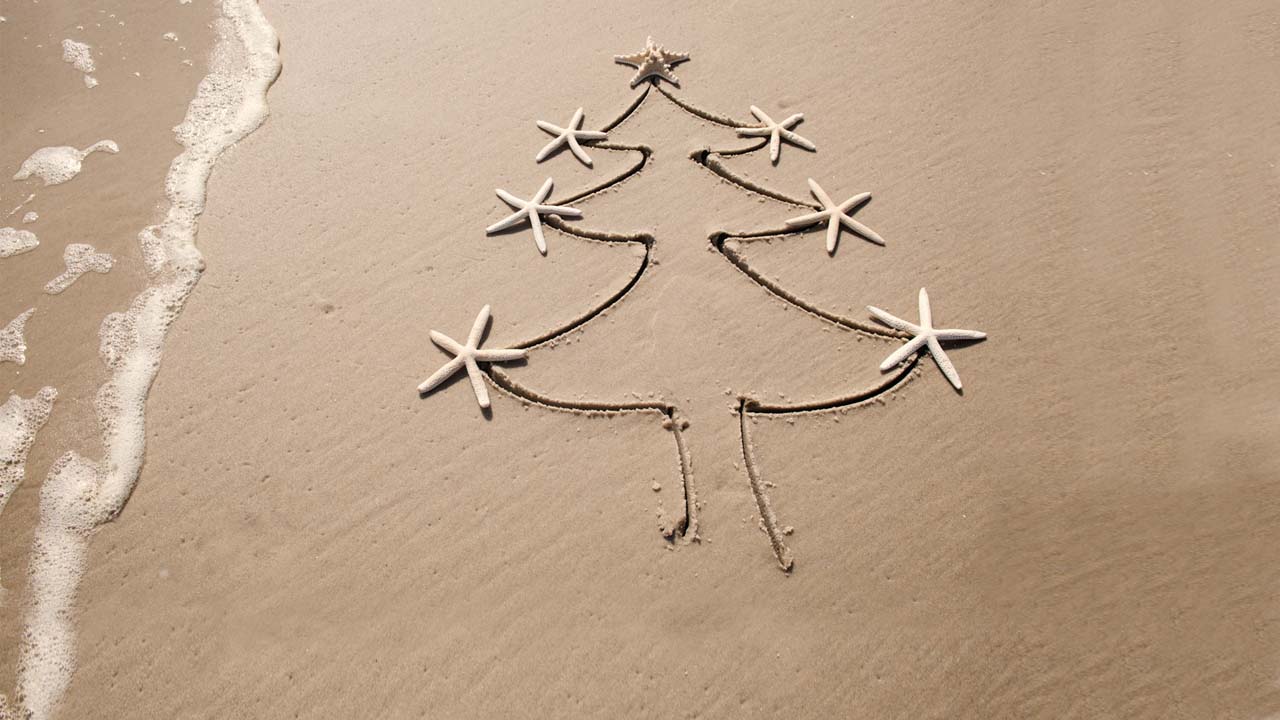 Árbol de Navidad dibujado en arena de playa