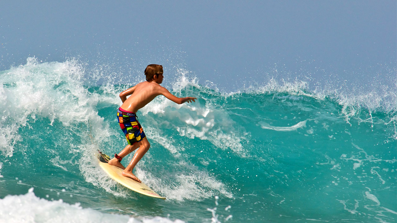 Niño surfeando en Gran Canaria