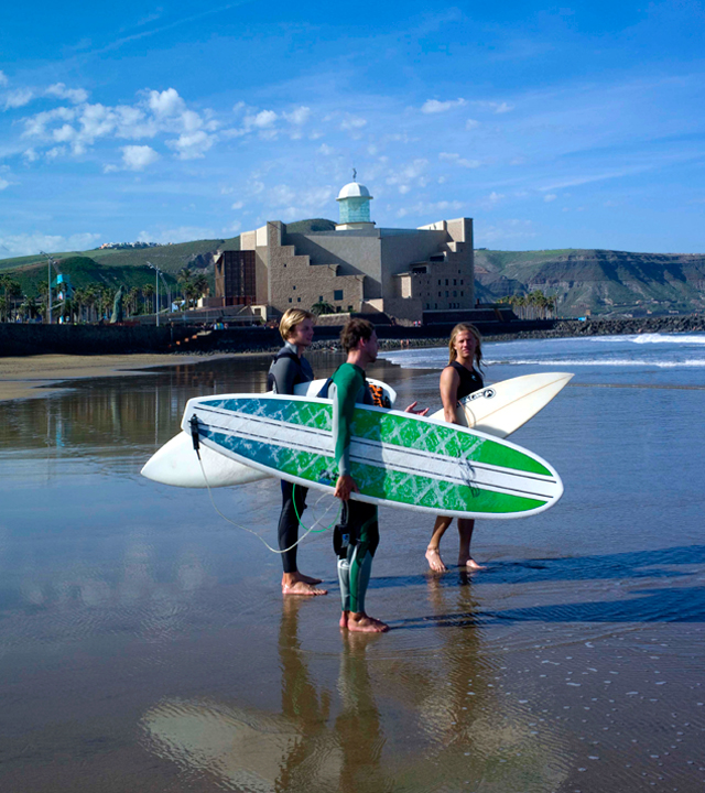 Surferos en la orilla de La Cícer, en la playa de Las Canteras, junto al Auditorio Alfredo Kraus