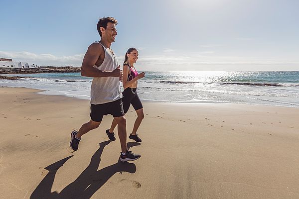 Pareja corriendo en la playa