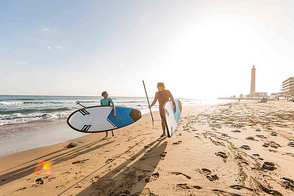 jóvenes con tablas de paddle surf en la playa de Maspalomas