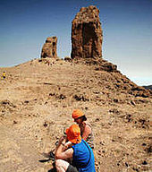 Deux randonneurs font une halte devant le Roque Nublo
