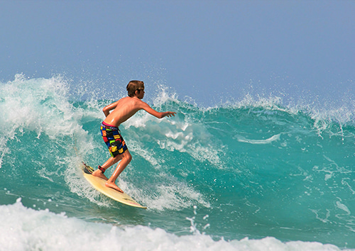 Niño surfeando en Gran Canaria