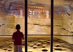 Un niño frente a las pinturas aborígenes de la Cueva Pintada