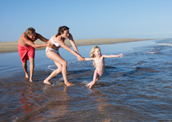 En familj springer ner till vattnet i Playa del Inglés