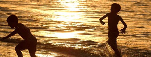 Des enfants jouent en bord de mer à Las Canteras en fin de journée