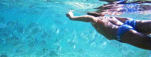 Un bambino fa un'immersione nel mare di Las Canteras