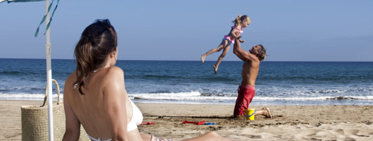 A father plays with his daughter on the shore