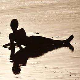 Duas jovens a rir sobre a areia de Las Canteras