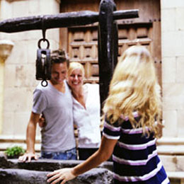 A group of frinds smiling by the well in the Casa de Colón