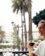 Junger Mann trinkt ein Glas Wein auf der Terrasse des Literarischen Kabinetts
