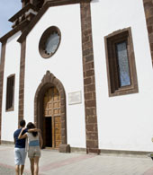 Una coppia passeggia davanti alla Chiesa di Artenara