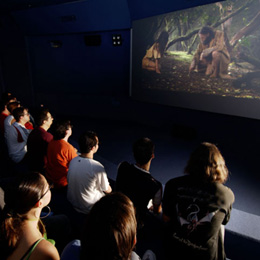 Visitors observing a video in the Museum and Archaeological Site of Cueva Pintada
