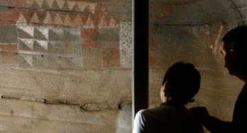 [] Dos visitantes observan las pintaderas de la Cueva Pintada de Gáldar