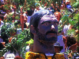 Giant-headed figure on stilts leads the way in La Rama de Agaete