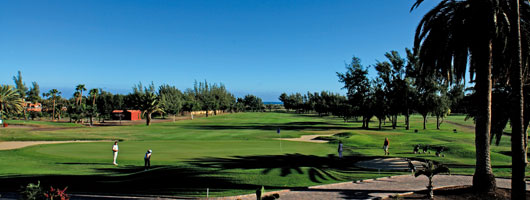 Panoramavy av en golfbana under blå himmel