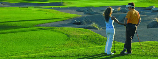 A couple talking on the green of Meloneras Golf