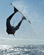 Kitesurferin fliegt im Manöver über das Wasser