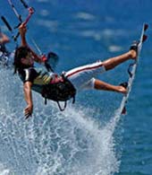 Kitesurfer fliegt im Manöver über das Wasser