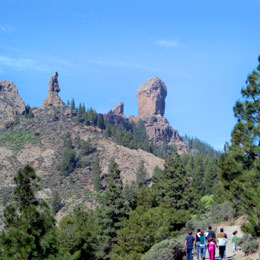 A group of people make their way to the base of the Roque Nublo