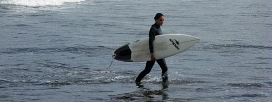 A surfer coming out of the water in Las Canteras