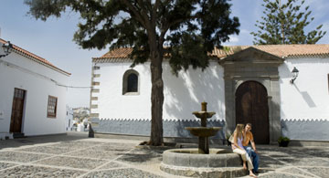 Couple chatting at the Fuente en la plaza de San Francisco square fountain