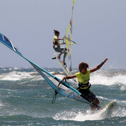 A windsurfer leaping over the waves