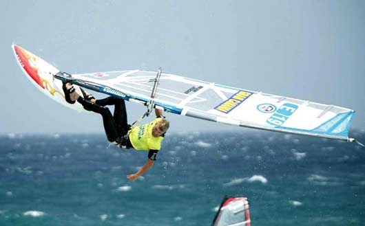 A windsurfer leaping over the waves