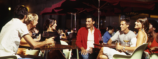 A group of friends laughing and chatting over a drink